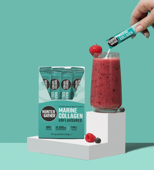 gb-en,eu-en | Hunter and Gather Marine Collagen packaging with a glass of water and lemon slices on a teal background.