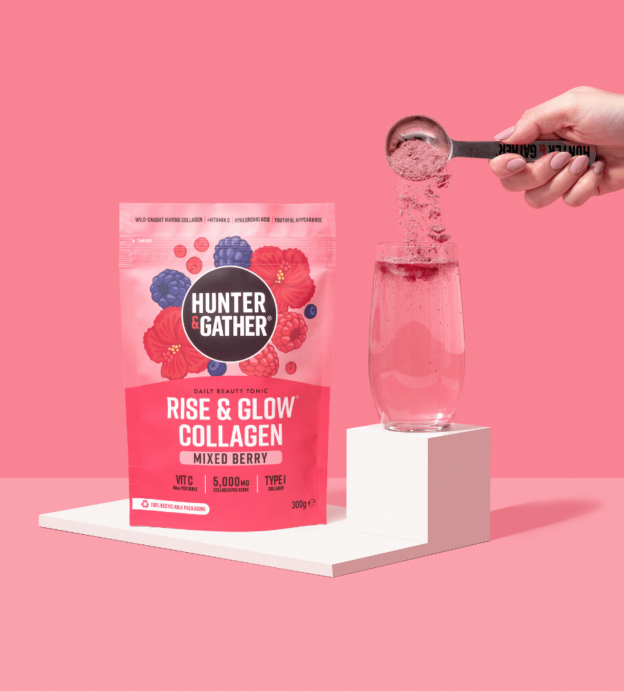 eu-en | Hunter & Gather Rise & Glow Collagen package with a hand pouring powder into a glass on a pink background.